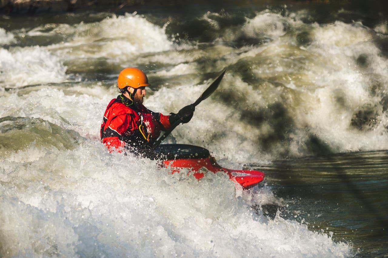 creative-03 Man kayaking through whitewater rapids, showcasing adventure and outdoor excitement.